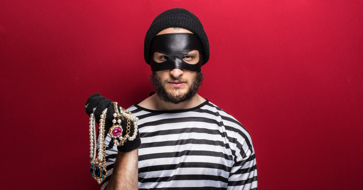 A masked thief holding a jewelry box, representing the threat of jewelry theft