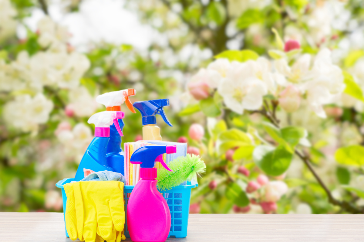 A collection of cleaning tools and supplies on a clean countertop, ready for spring cleaning