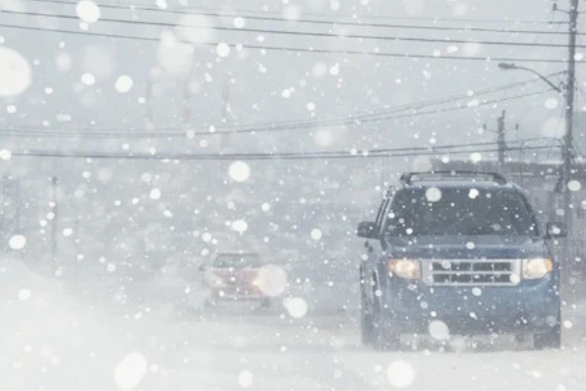 Driver navigating a snowy road during a whiteout