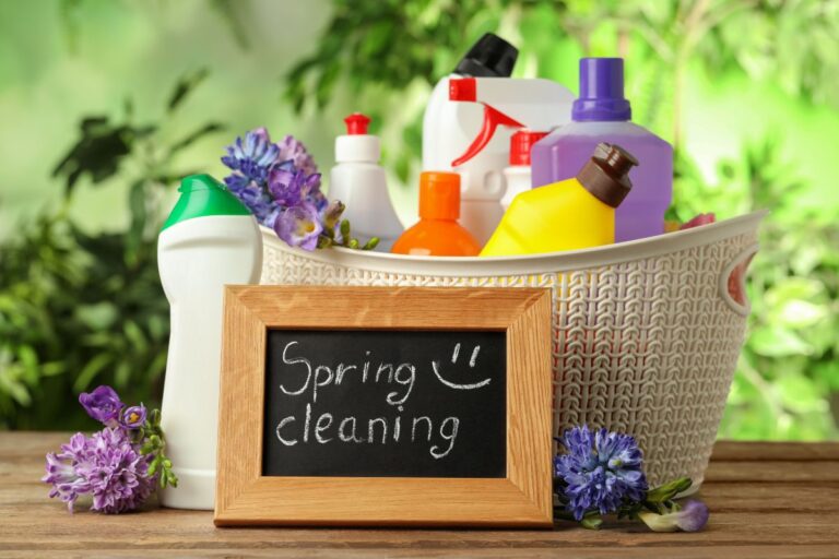 Assorted household cleaning products including spray bottles, disinfectants, and cloths arranged for home cleaning