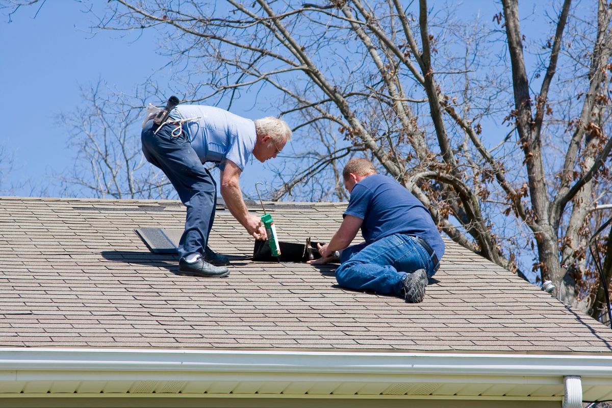 Roofer inspecting shingles on a residential roof