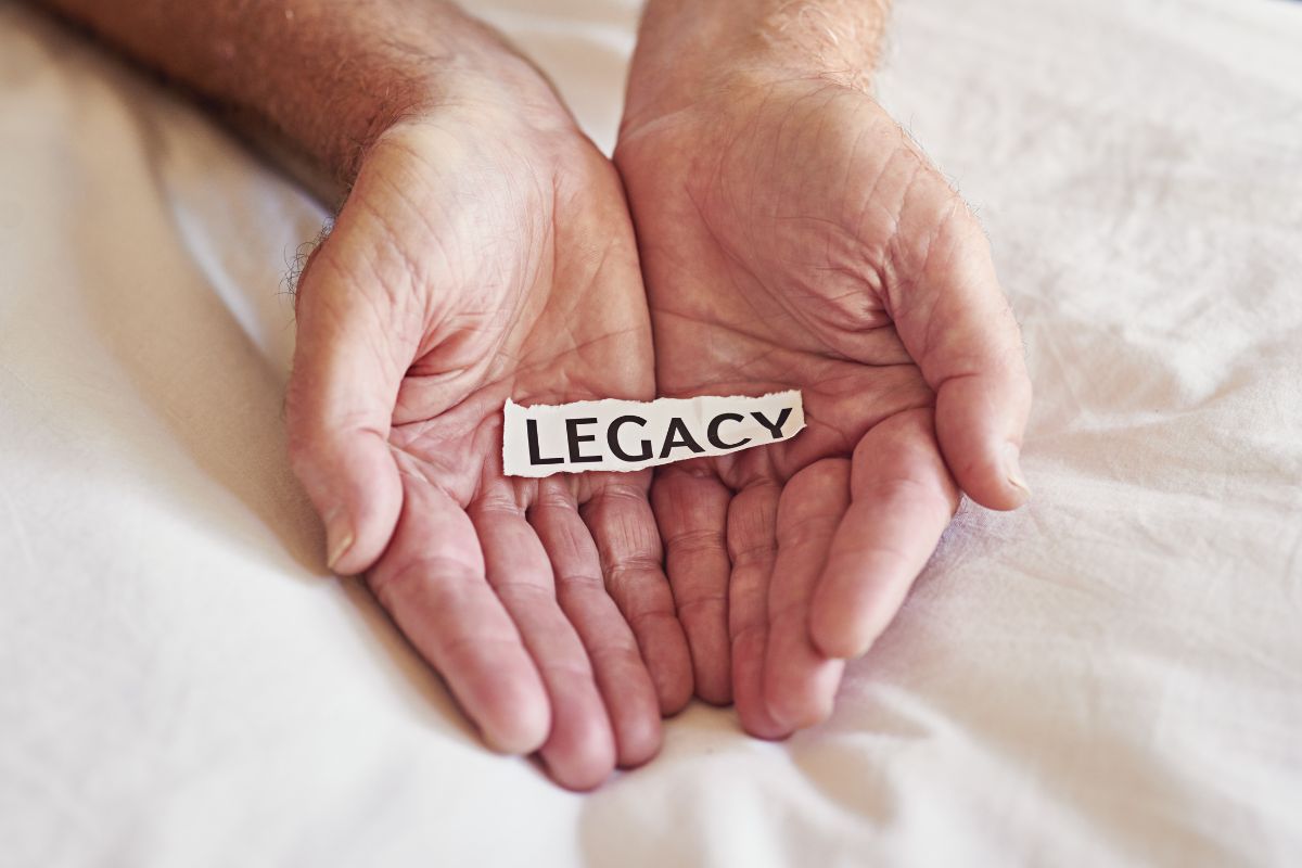 Hands of an elderly person gently holding a younger hand, symbolizing passing on love, security, and a lasting legacy through life insurance.