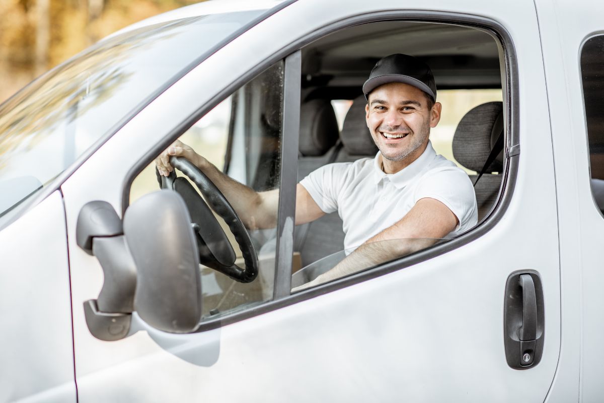 Driver sitting behind the wheel of a car, representing the difference between personal and work vehicle use.