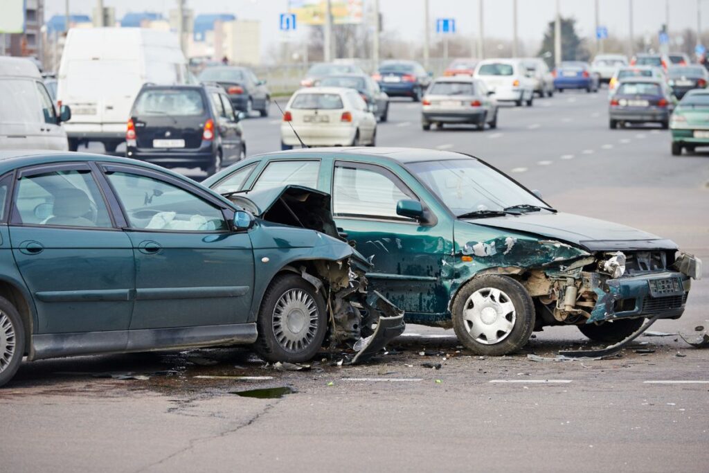 Driver looking at a damaged car after an accident, highlighting the importance of collision coverage.