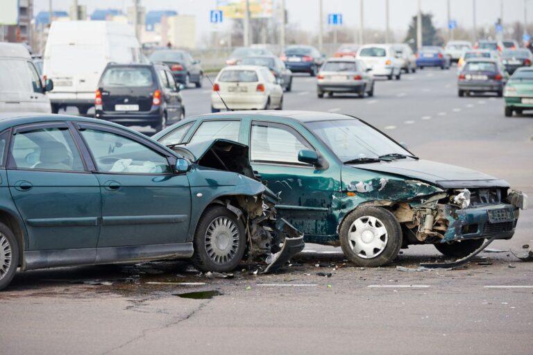 Driver looking at a damaged car after an accident, highlighting the importance of collision coverage.
