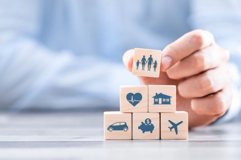 Smiling couple reviewing their bundled insurance policy with an agent, showing how bundling helps them save money.