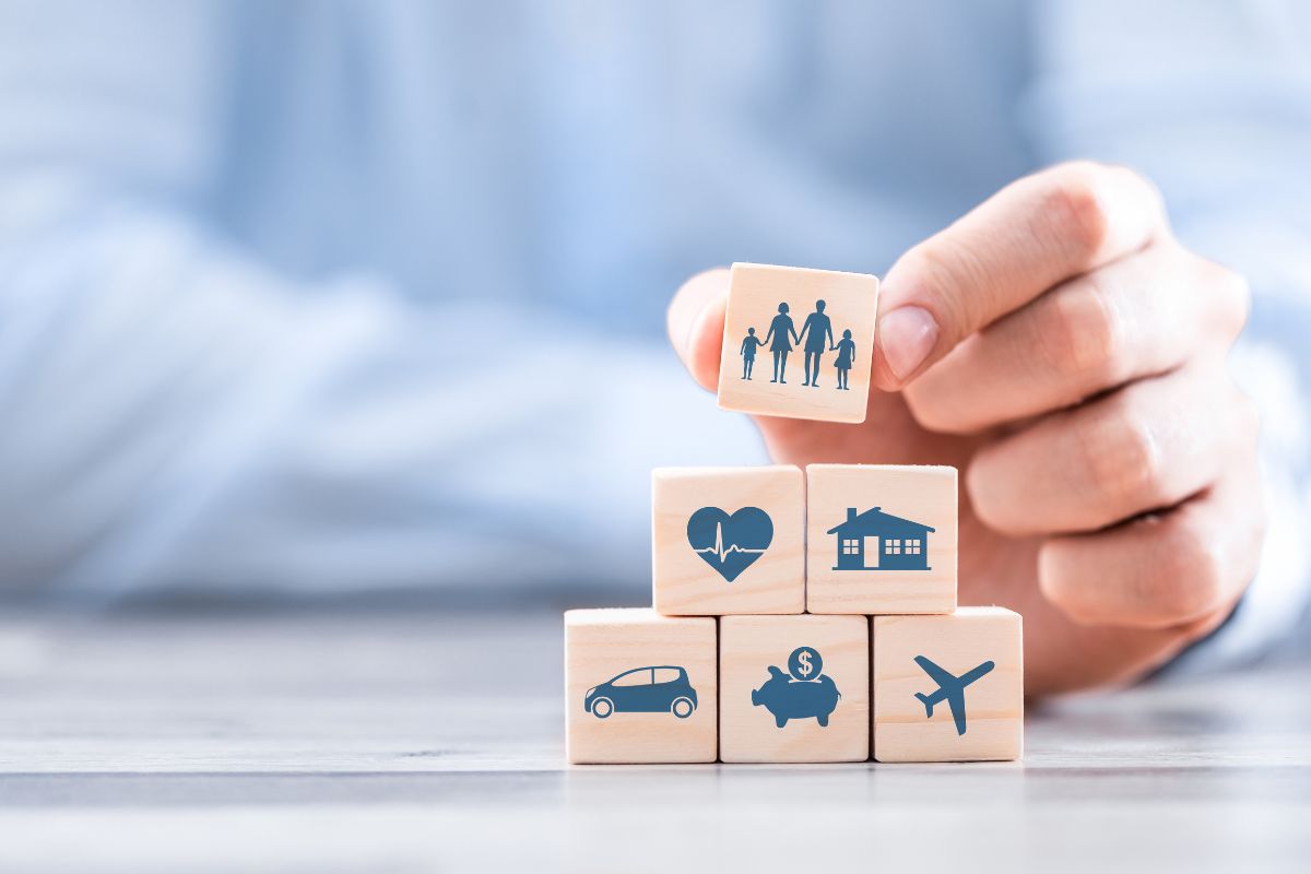 Smiling couple reviewing their bundled insurance policy with an agent, showing how bundling helps them save money.