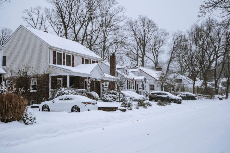 A cozy home decorated for the holidays with snow on the roof, symbolizing winter safety and readiness.