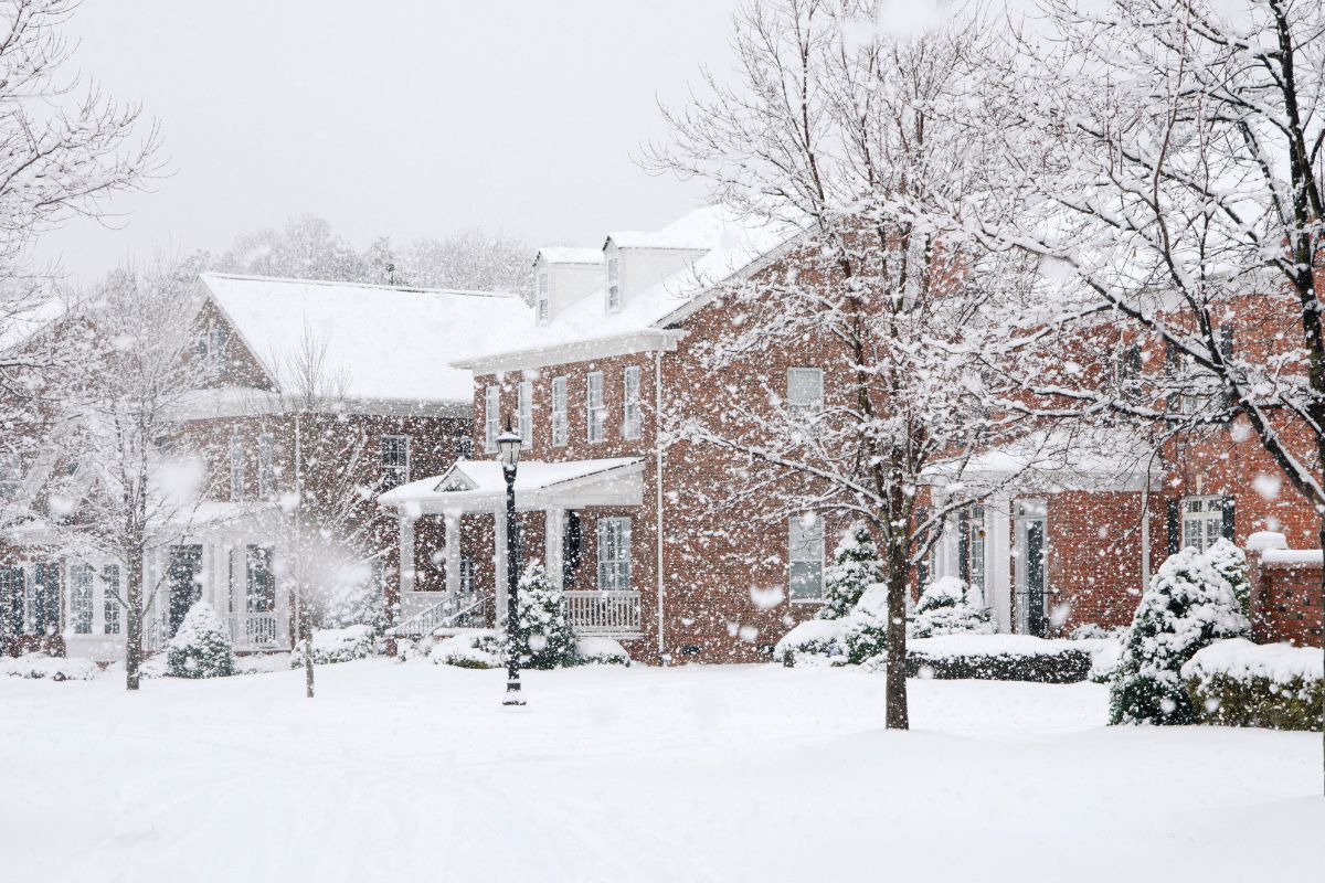 Home covered in snow during a winter storm, showing proper winter protection measures.