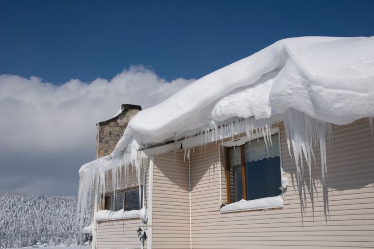 Ice dam forming on a roof, showing snow buildup and potential water damage to shingles and gutters