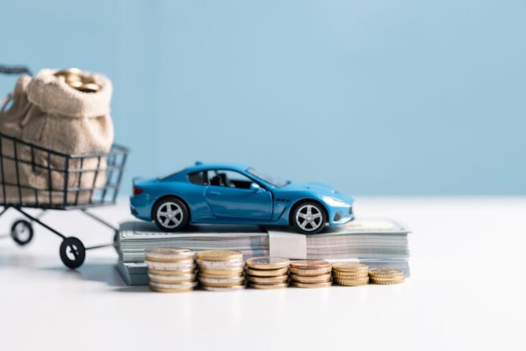 A car parked with coins and dollar bills around it, symbolizing money saved on auto insurance