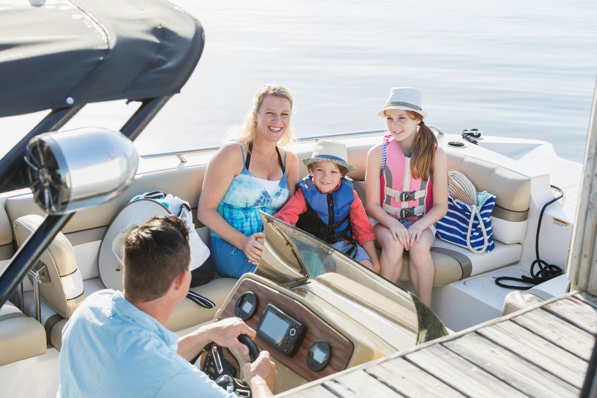 Family wearing a life jacket while checking boat safety equipment before heading out on the water