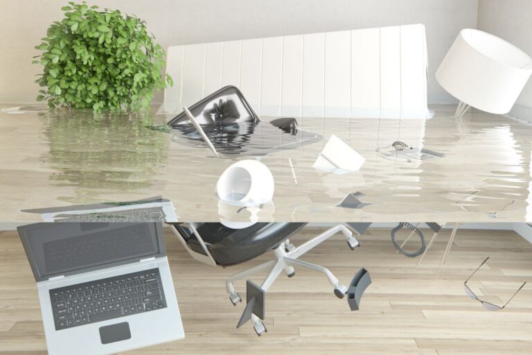Flooded office with damaged furniture and office supplies, illustrating the impact of disasters on business operations