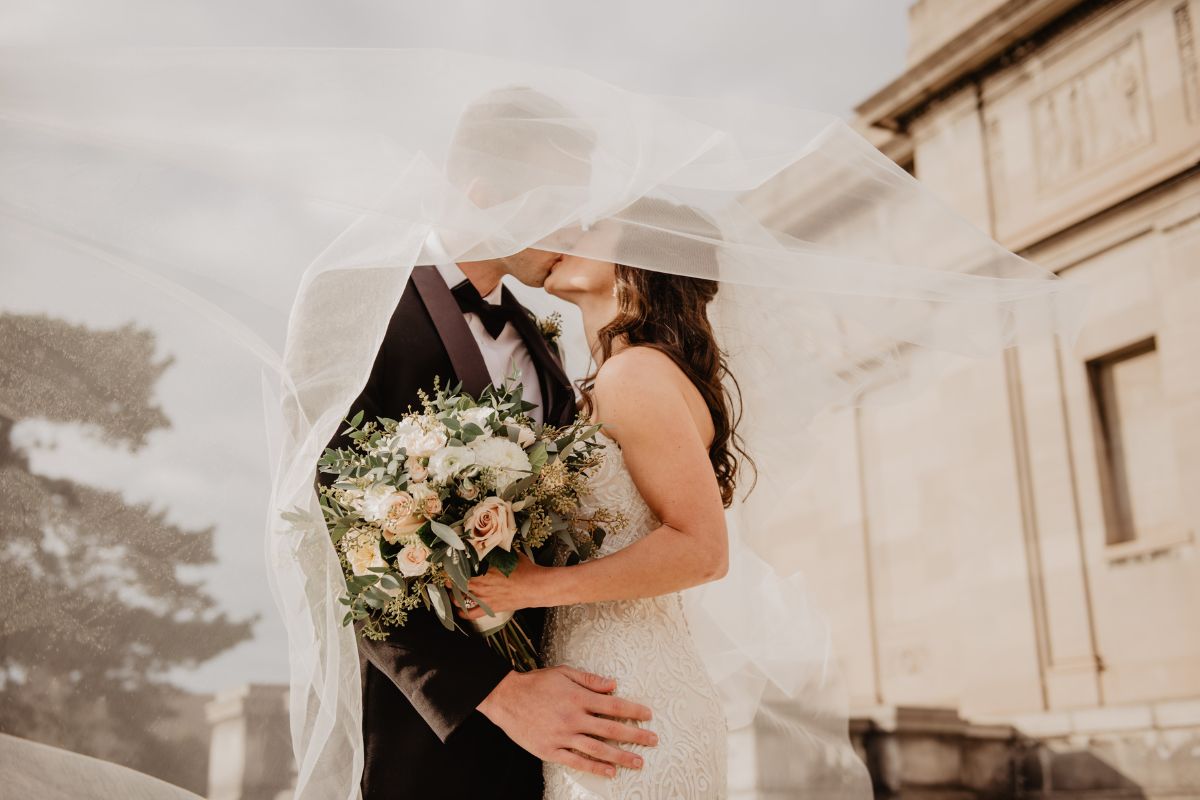 Wedding couple with a protective shield symbolizing wedding insurance coverage