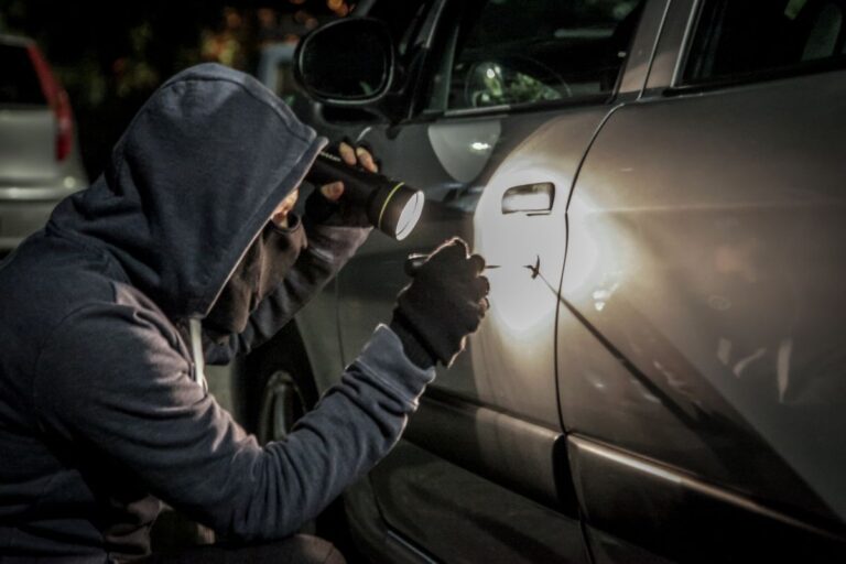 A parked car in a public area with emphasis on vehicle security and theft prevention awareness.