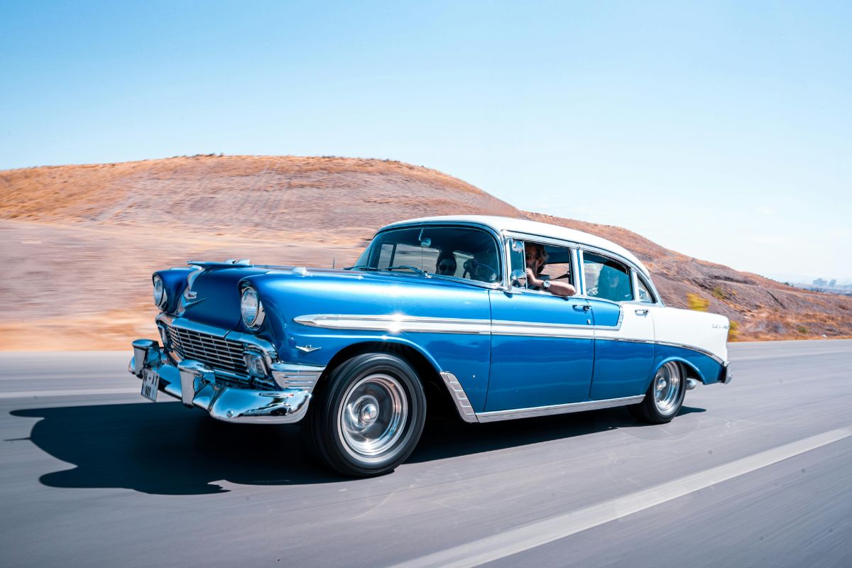 Red classic vintage car parked outdoors, showcasing its restored condition and collector value.